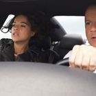 Ein Mann und eine Frau sitzen in einem Auto. Der Mann fährt konzentriert, die Frau hält sich fest.