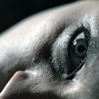 Kein Text vorhanden. Nahaufnahme eines liegenden Gesichts, der Fokus liegt auf einem geöffneten Auge.