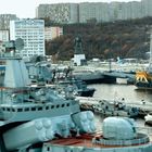 Text: "ПК-7500". Im Vordergrund Schiffe im Hafen, Hintergrund hohe Gebäude und eine große Statue.