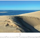 "Atlantik Düne von Pyla" steht unten. Eine große Sanddüne und das Meer bei klarem Himmel.