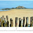 Fortress Island. Ein sandiger Strand mit Holzpfählen im Vordergrund und einer Insel mit Festung im Hintergrund.