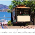 "Hyde Street Cable Car" und Kalendarium. Eine Kabelbahn fährt einen Hügel hinab, die Bucht und Segelboot im Hintergrund.