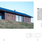 "LIVING IN THE DELTA" steht links vertikal. Holzhaus mit blauen Dach, große Fenster, auf grünem Hügel. Grundriss unten.