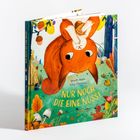 „NUR NOCH DIE EINE NUSS!“. Ein rotes Eichhörnchen hält eine Nuss, umgeben von Wald und bunten Blättern.