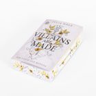 Auf einer Buchverpackung steht "VILLAINS ARE MADE" und "DER FLUCH DER MEDUSA", verziert mit goldenen Blättern und Rosen.