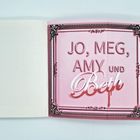 JO, MEG, AMY UND Beth in stilvoller Schrift auf rosa Hintergrund mit dekorativem Rand. Links leeres Buch.