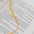 Ein aufgeschlagenes Buch mit sichtbarem Text und einem gelben Lesebändchen.