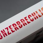 Der Text „UNZERBRECHLICH“ ist in roten Buchstaben auf einem weißen Hintergrund zu sehen.