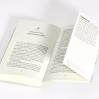 Eine aufgeschlagene Buchseite mit der Überschrift „Wir brauchen etwas, woran wir glauben können“ und einer eingelegten Karte.