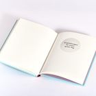 Ein aufgeschlagenes Buch zeigt die Worte "Empfehlungen für einen guten Tag" in einem Kreis auf der rechten Seite.