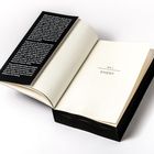 Links: Schwarzer Klappentext über das Leben in einer Monotonie. Rechts: "Teil 1 Emery" in einem geöffneten Buch.