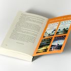 „JOHN GRISHAM BEI HEYNE“ steht auf einer farbigen Buchwerbung im offenen Buch, zusammen mit vier seiner Buchtitel.