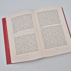 Ein aufgeschlagenes Buch zeigt Text auf zwei Seiten, nummeriert mit 82 und 83. Der Einband ist rot.
