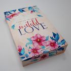 „Teresa Sporrer, untold LOVE“ auf floraler Box mit rosa und blauen Blüten.