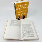Das Buch "Gespräche mit Freunden" von Sally Rooney steht aufrecht. Ein Exemplar liegt offen daneben.