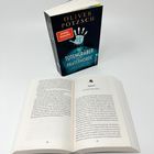 Ein geschlossenes Buch mit der Aufschrift "Oliver Pötzsch: Der Totengräber und die Pratermorde" steht hinter einem geöffneten Buch.