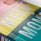 Der Text „MEAN MOMS“ und „EMMA ROSENBLUM“ ist in großer Schrift zu sehen. Eine Frau liegt am Pool, umgeben von bunten Farben.