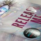 Zu lesen ist "RELEASE ME". Daneben ein stilvoll gezeichnetes Auge mit strahlenden Farben und Diamanten.
