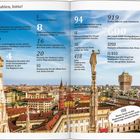 Zahlen über Mailand, darunter bekannte Gebäude, Bevölkerung und kulturelle Fakten. Hintergrund: Stadtansicht mit Domstatuen.