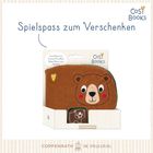 "Spielspass zum Verschenken", Stoffbuch mit süßem Bären, lächelndes Gesicht, Logo "Cosy Books" oben rechts.