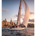 Text: "Calypso", Kalendernummern darunter. Segelboot vor historischer Küste im Abendlicht, Menschen an Bord.