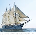 Kalenderdarstellung eines traditionellen Segelschiffs mit vielen Segeln auf offenem Meer unter blauem Himmel.