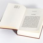 Ein geöffnetes Buch zeigt den Text "Erstes Buch" und "Erstes Kapitel". Am linken Rand ist ein Inhaltsverzeichnis.