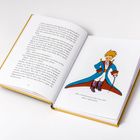 Eine Buchseite mit Text und der Illustration eines kleinen Prinzen in blauem Mantel auf der rechten Seite.