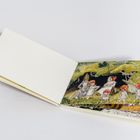 Auf einer Buchseite: Illustration von Figuren mit roten Pilzmützen in einer Waldlandschaft. Links leere Seiten.