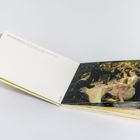 Offenes Buch mit Gemälde von Peder Severin Krøyer: Menschen sitzen an einem Tisch und heben Gläser.