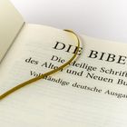 "DIE BIBEL, Die Heilige Schrift des Alten und Neuen Bundes, Vollständige deutsche Ausgabe." Geöffnete Buchseite mit Lesezeichen.