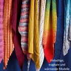"Vielseitige, tragbare und wärmende Modelle." Verschiedene bunte, gestrickte Tücher hängen nebeneinander.