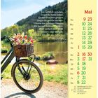 Kalenderblatt Mai, Zitat: "Um wirklich zu leben, musst du heute leben." Fahrrad mit Blumenkorb am See.