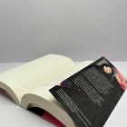 Ein aufgeschlagenes Buch mit einem lose eingelegten Flyer über jemand mit verschiedenen Textinformationen.