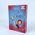 Buchtitel: "Floh im Ohr". Ein Junge mit rotem Haar und ein Schlauchhund tanzen fröhlich. Musiknoten umgeben sie.