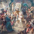 Eine belebte mittelalterliche Szene mit Menschen und Pferden. Ein Reiter auf weißem Pferd, Fahnen und ein Hund.