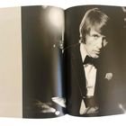 Seite 104. Schwarz-Weiß-Foto eines Mannes im Anzug, der ernst schaut, links eine leere Seite.