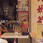 12:00 PM / 15:00 PM, DIM SUM. Straßenszene mit Menschen, Tisch, Getränkekrüge, Essstäbchen und chinesische Schriftzeichen.