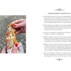 SCHNELLKURS »BAGUETTE«: Infos zu Baguettearten und -traditionen. Bild: Hände brechen ein Baguette, rote Nägel, gepflasterter Boden.