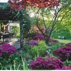 Kalenderseite Juni mit blauem Gartenmöbel-Set vor blühendem Rosenbusch.