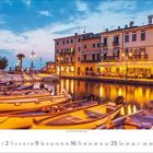 Kalender mit Datum 1-31 in Juli. Malerische Hafenszene mit bunten Gebäuden, Booten im Wasser und Restaurants mit Sonnenschirmen.