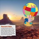 Text: "Monument Valley. Das Monument Valley liegt in den USA. In dieser Landschaft gibt es viele rote Felsen, die wie Türme aussehen. Sie bestehen aus Sandstein, der aus ganz vielen kleinen Sandkörnern entstanden ist. Vor vielen Millionen Jahren lag dort Sand, der zu Stein wurde. Wind und Regen haben den weichen Sand weggespült, sodass nur die harten Felsen übrig blieben." Illustration: Bunter Heißluftballon mit Elefant und Hase über Landschaft.