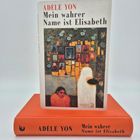 Der Text auf dem Cover lautet: "ADÈLE YON Mein wahrer Name ist Elisabeth". Eine künstlerische Illustration zeigt zwei Figuren.