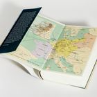 Text über Entdecker und Abenteuer auf einer geöffneten Buchseite mit einer farbigen Europakarte des 18. Jahrhunderts.