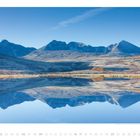 Mai 01 02 03 04 05 06 07 08 09. Berglandschaft spiegelt sich in ruhigem See, klarer blauer Himmel.