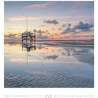 „05“ in großen Ziffern. Ein Pfahlbau am Strand spiegelt sich im Wasser. Dramatischer Himmel bei Sonnenuntergang.