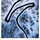 17 So, 02. Woche 2027, JANUAR. Verschneite, kurvige Straße durch eine Winterlandschaft mit schneebedeckten Bäumen.