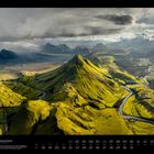 05 Hochland in Island. Eindrucksvolle Berglandschaft mit grünen Hügeln und einem sich windenden Fluss unter dramatischem Himmel.