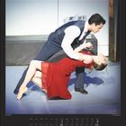 Text: "Anna Karenina. Mai | May"
Ein Paar tanzt elegant, die Frau trägt ein rotes Kleid, beide in einer dramatischen Pose.