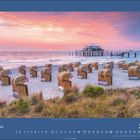 Mai 2027: Ein Strand mit Strandkörben beim Sonnenuntergang. Im Hintergrund ein Gebäude auf Stelzen im Meer.